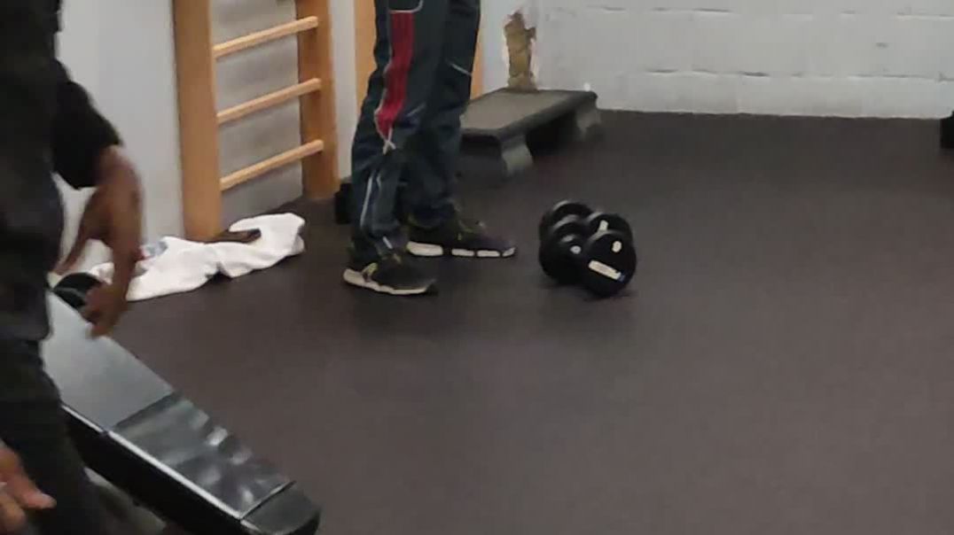 A masked soy boy stretching at a gym !