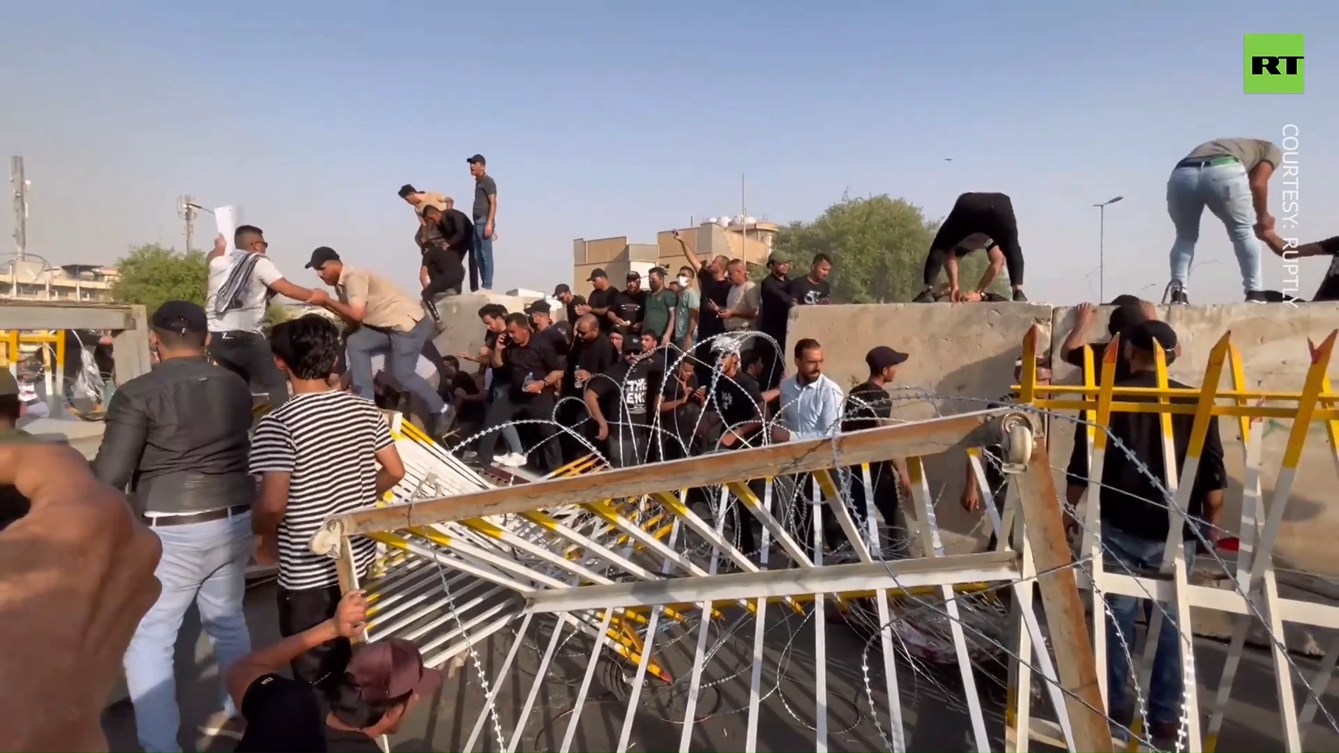 Protesters tackle wall of barbed wire near occupied parliament in Iraq