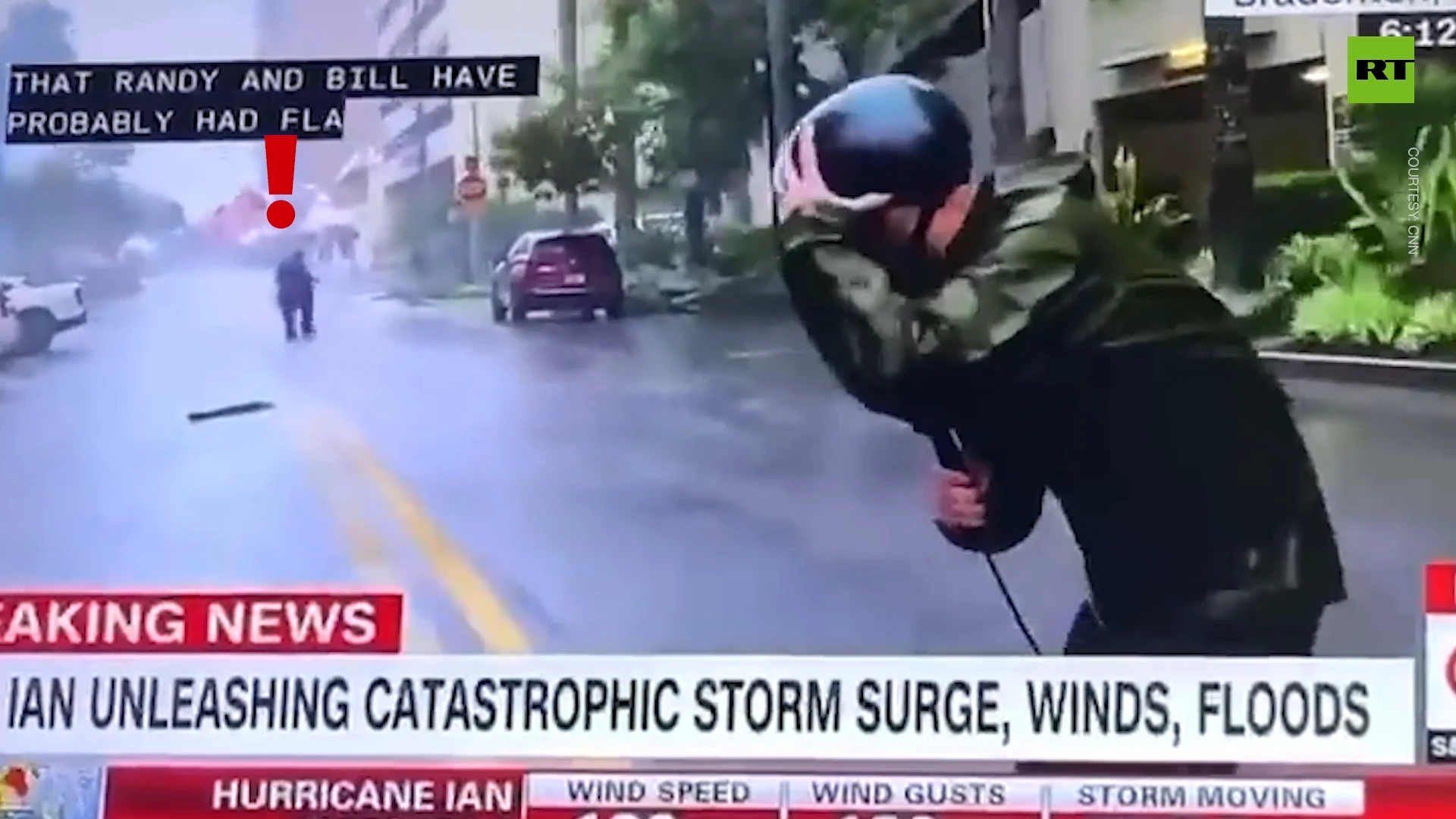 Man calmly walks and gets in car during exaggerated CNN hurricane report