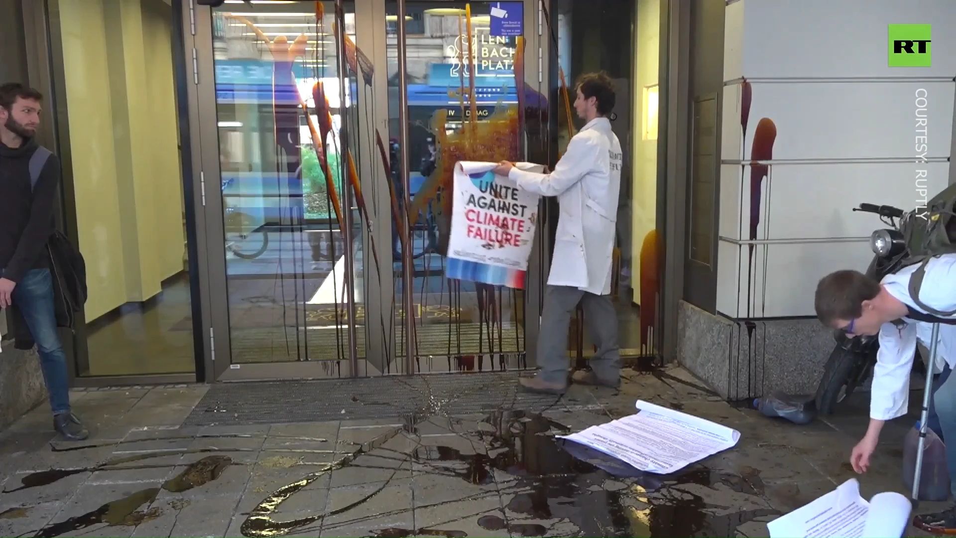 Protesters spray oil & throw coal at company investing in fossil fuels