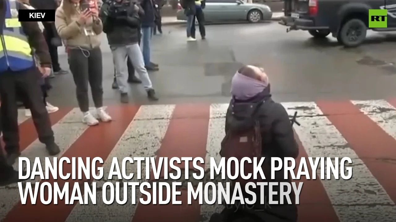 Dancing activists mock praying woman outside monastery