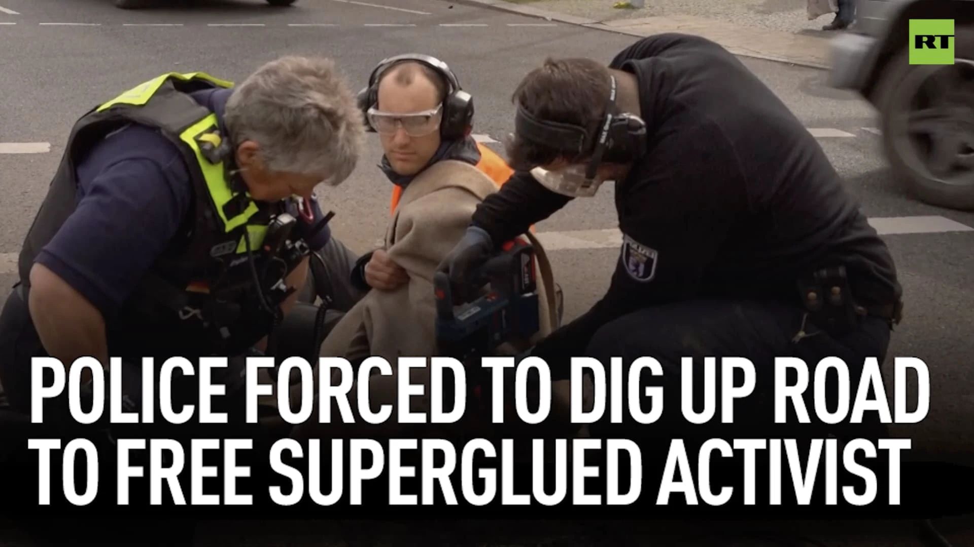 Police forced to dig up road to free superglued activist