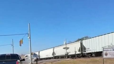 Train crashes into truck with cars on it